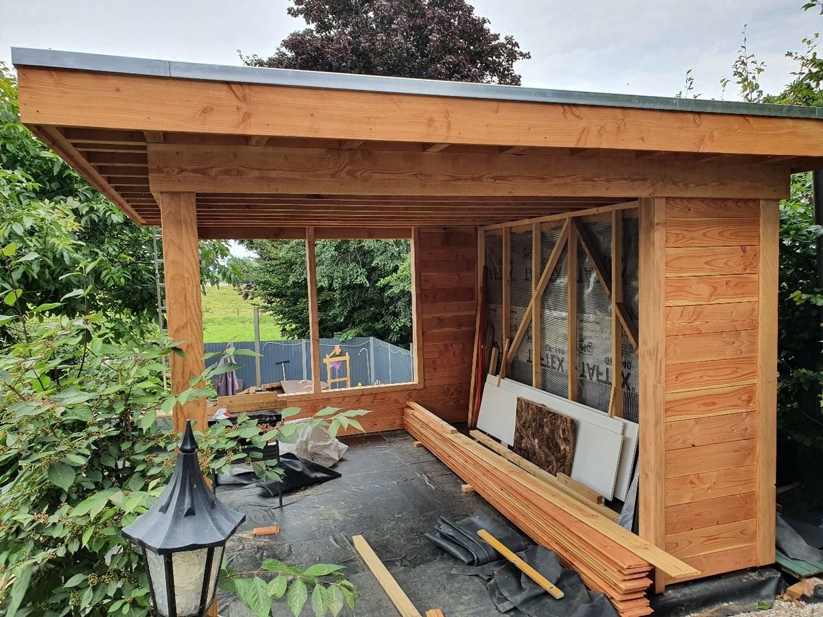 Douglas constructie van een tuinhuis met overkapping in aanbouw